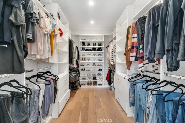 walk in closet with light hardwood / wood-style floors