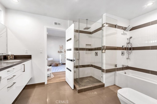 full bathroom featuring vanity, toilet, tile patterned floors, and plus walk in shower