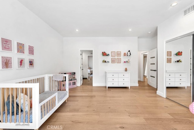 bedroom with light hardwood / wood-style flooring and a closet