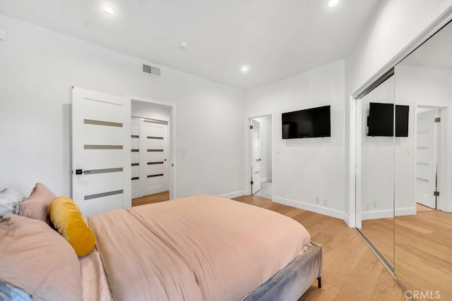 bedroom with wood-type flooring and a closet