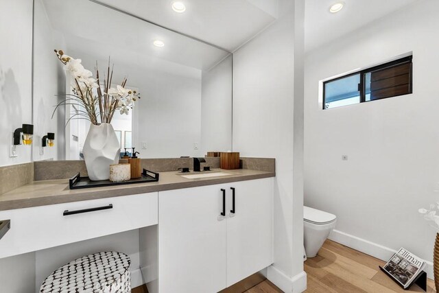 bathroom with vanity, hardwood / wood-style floors, and toilet