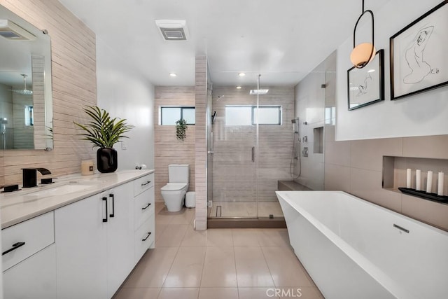 full bathroom featuring toilet, separate shower and tub, tile walls, vanity, and tile patterned flooring