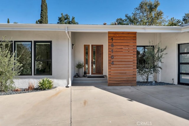 view of exterior entry with a patio area