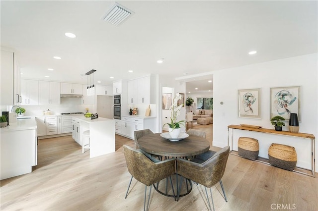 dining space featuring sink and light wood-type flooring