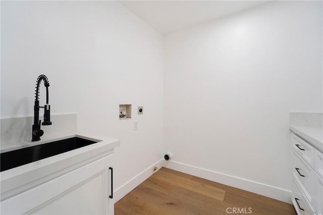 clothes washing area with washer hookup, sink, hookup for an electric dryer, and light wood-type flooring