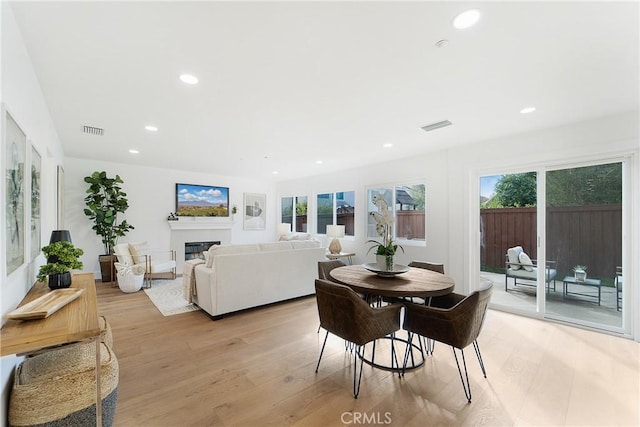 dining room with light hardwood / wood-style flooring and a healthy amount of sunlight