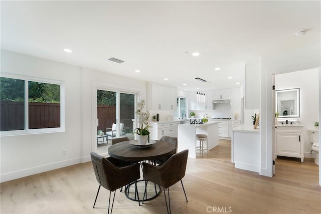 dining area featuring sink and light wood-type flooring