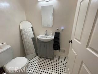 bathroom featuring vanity, tile patterned flooring, and toilet