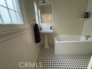 bathroom featuring tile patterned flooring, sink, and a bath