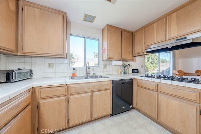 kitchen with sink, gas cooktop, dishwasher, a wealth of natural light, and tile counters