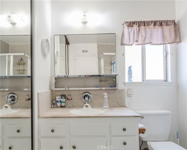 bathroom featuring tasteful backsplash, vanity, toilet, and walk in shower