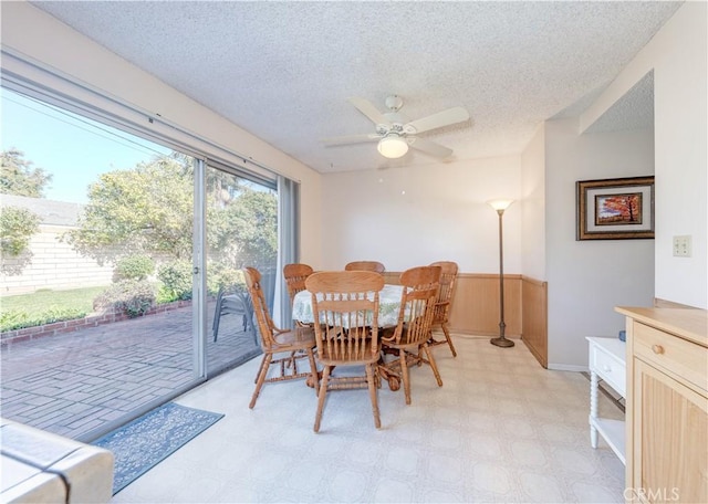 dining area with ceiling fan and a textured ceiling