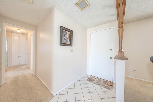 carpeted entryway with a textured ceiling