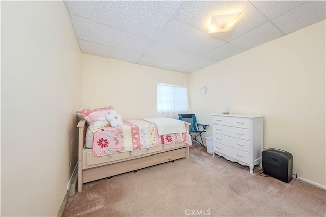 carpeted bedroom featuring a drop ceiling