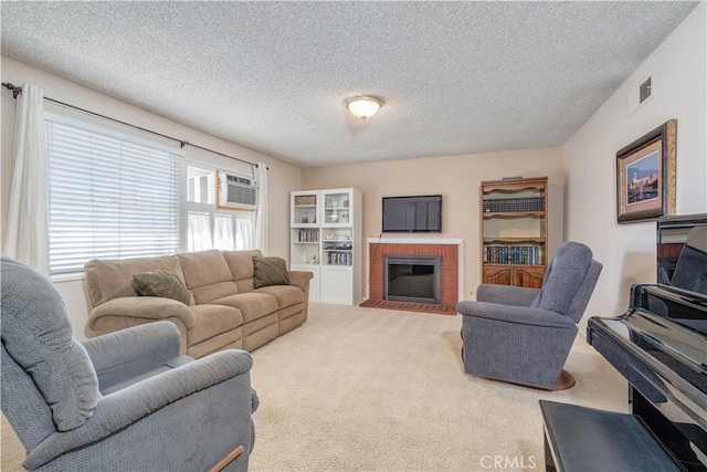 living room featuring carpet flooring, a textured ceiling, a brick fireplace, and an AC wall unit