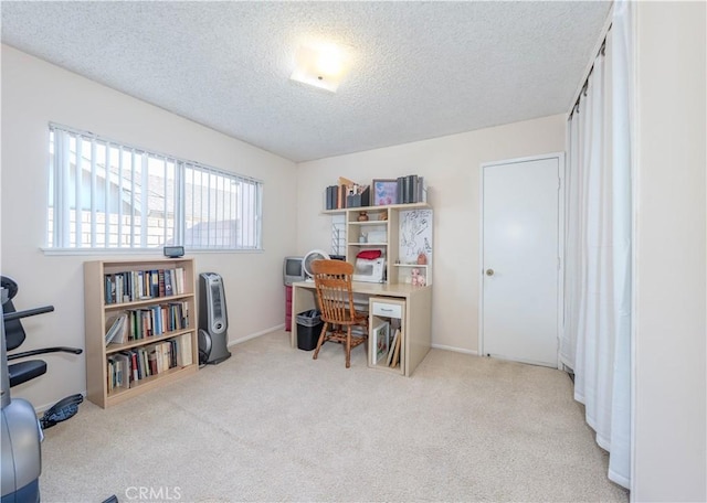 carpeted home office featuring a textured ceiling