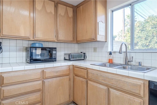 kitchen with sink, tasteful backsplash, black appliances, light brown cabinetry, and tile countertops