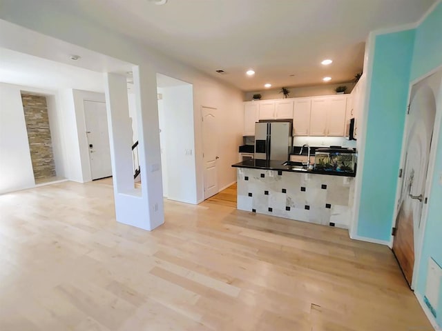 kitchen featuring stainless steel appliances, light hardwood / wood-style floors, sink, and white cabinets