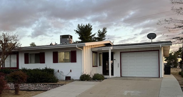 ranch-style house with a garage and central AC unit