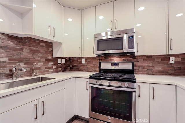 kitchen featuring stainless steel appliances, white cabinetry, and backsplash