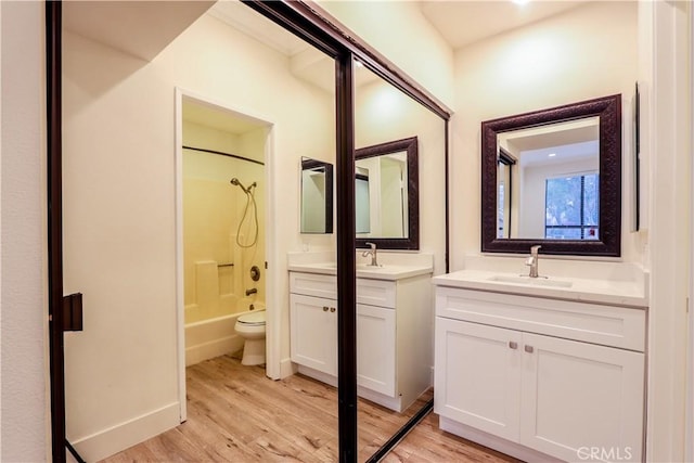 full bathroom with vanity, hardwood / wood-style floors, shower / bathtub combination, and toilet