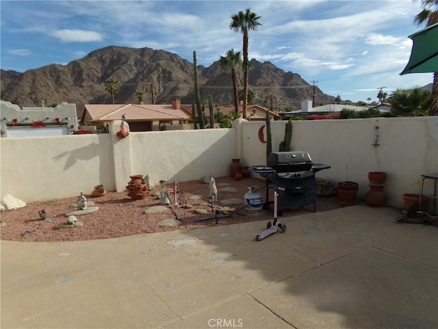 view of patio with area for grilling and a mountain view