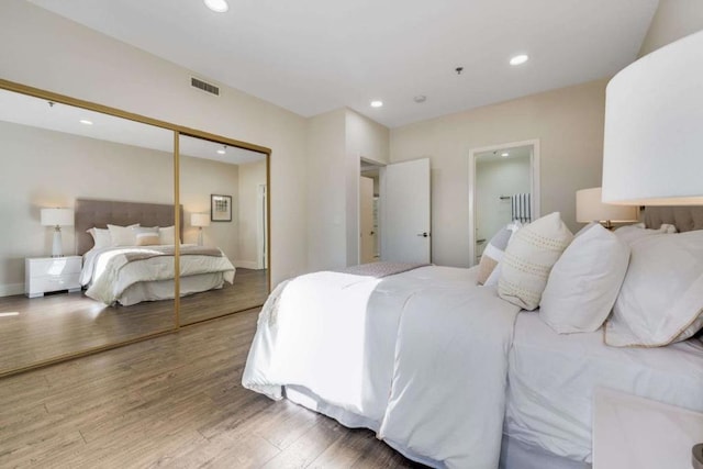 bedroom featuring ensuite bathroom, hardwood / wood-style floors, and a closet