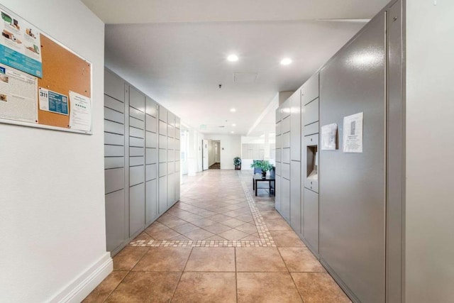 corridor with a package area and light tile patterned floors