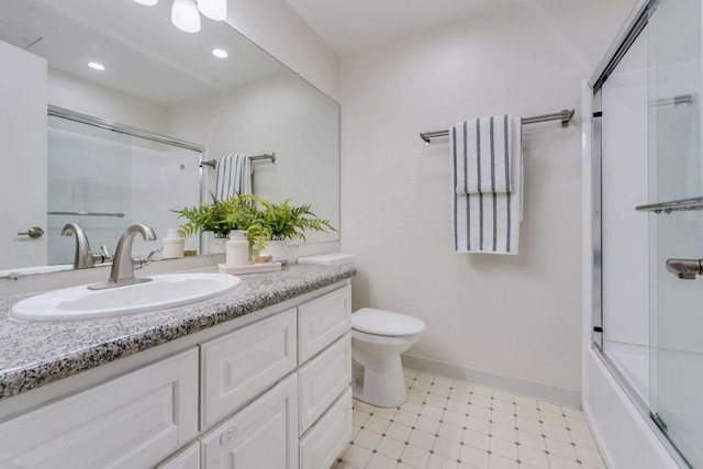 full bathroom with enclosed tub / shower combo, vanity, and toilet