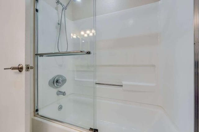 bathroom featuring bath / shower combo with glass door