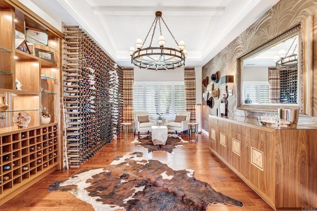 wine area with beamed ceiling, an inviting chandelier, and light wood-type flooring