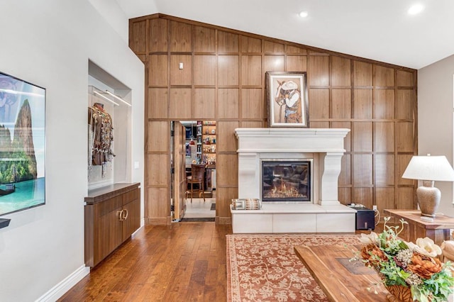 living room featuring lofted ceiling and wood walls