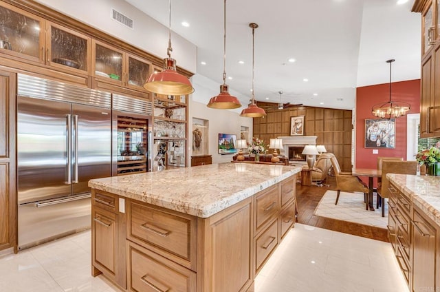 kitchen with a center island, a notable chandelier, light tile patterned flooring, decorative light fixtures, and built in fridge