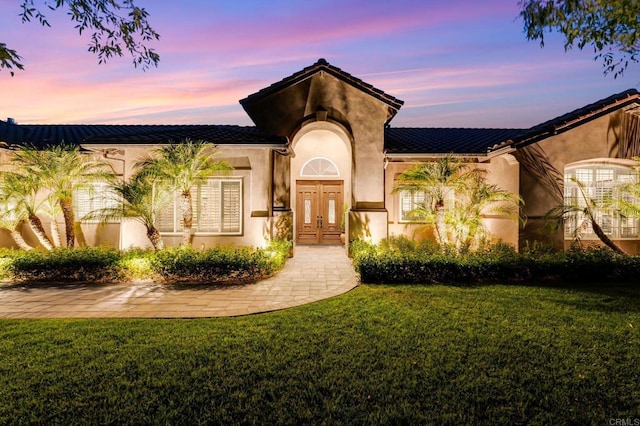 mediterranean / spanish house with a lawn