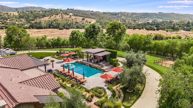 view of swimming pool with a mountain view and a patio