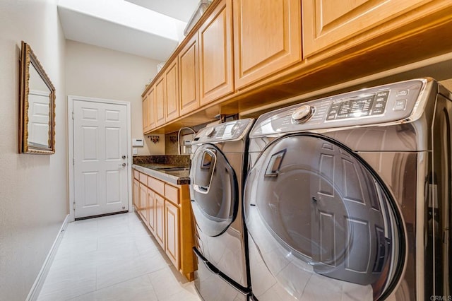 laundry room with sink, independent washer and dryer, light tile patterned floors, and cabinets