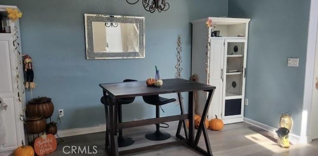 dining room featuring an inviting chandelier, baseboards, and wood finished floors