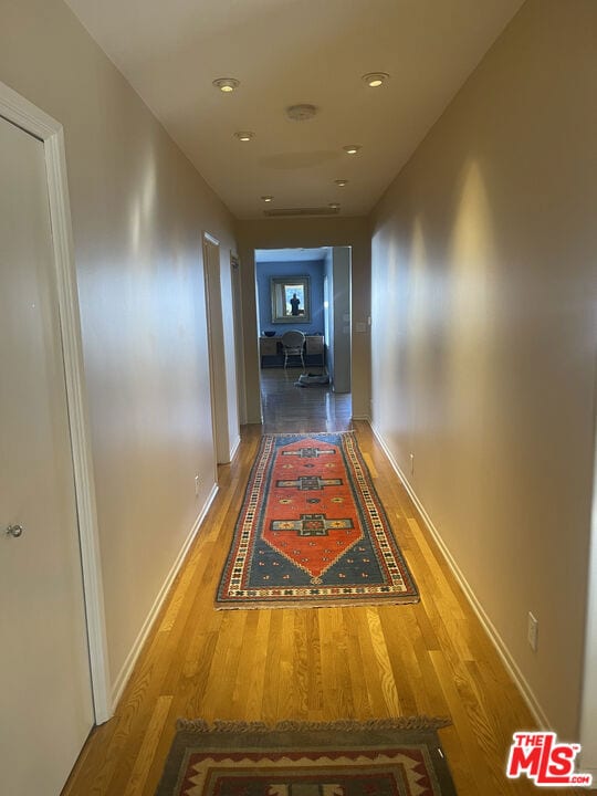 corridor with hardwood / wood-style floors