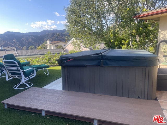 wooden deck with a hot tub and a mountain view