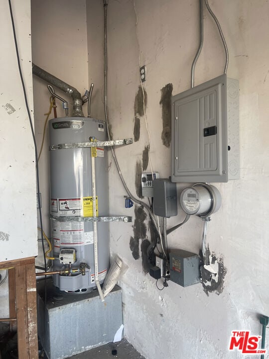 utility room featuring strapped water heater and electric panel