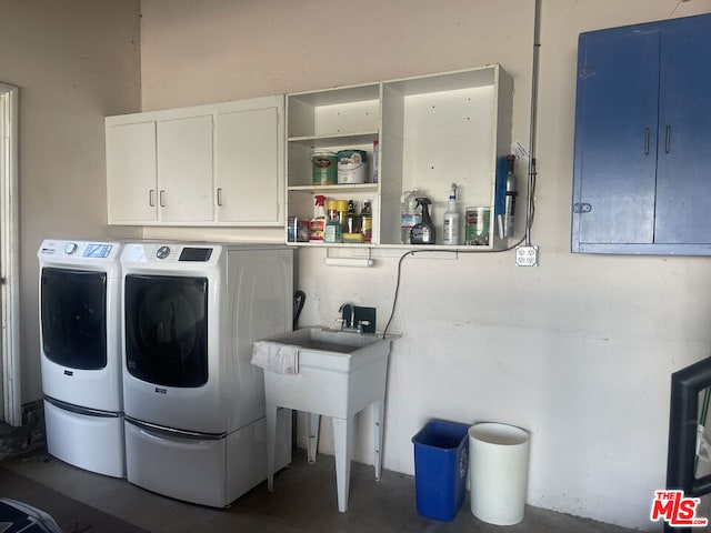 clothes washing area with cabinets and washing machine and clothes dryer