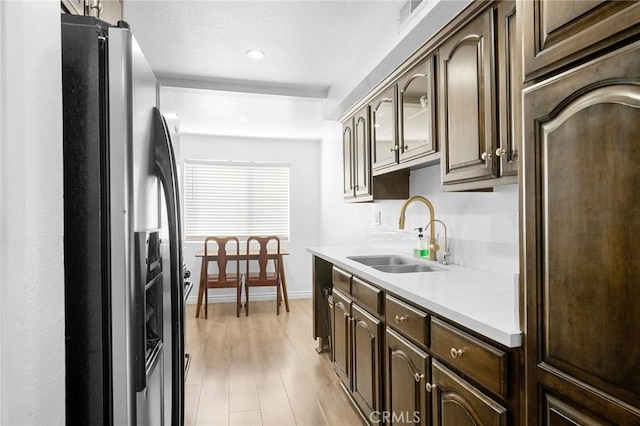 kitchen featuring sink, stainless steel fridge with ice dispenser, and dark brown cabinets