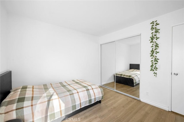 bedroom featuring hardwood / wood-style floors and a closet