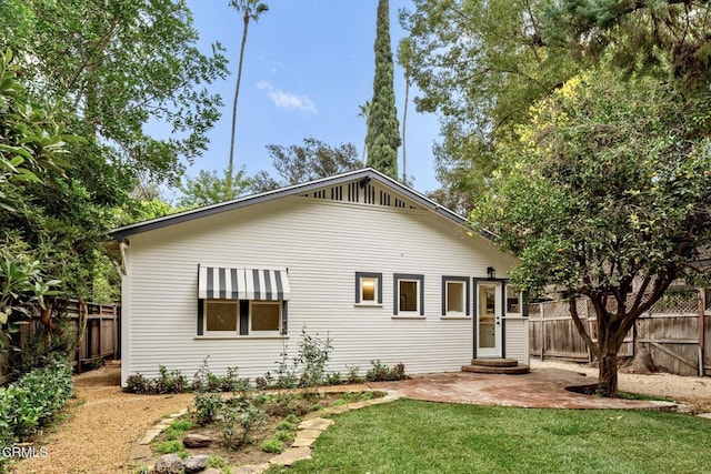 back of property with a patio and a lawn