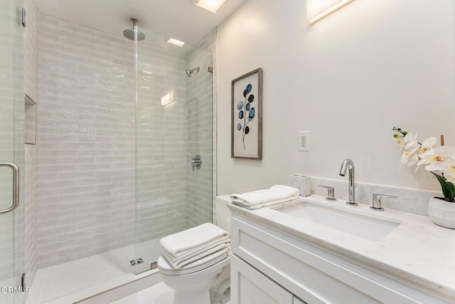 bathroom with vanity, toilet, and a shower with shower door