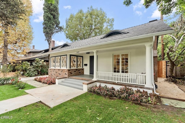 ranch-style house with covered porch and a front yard