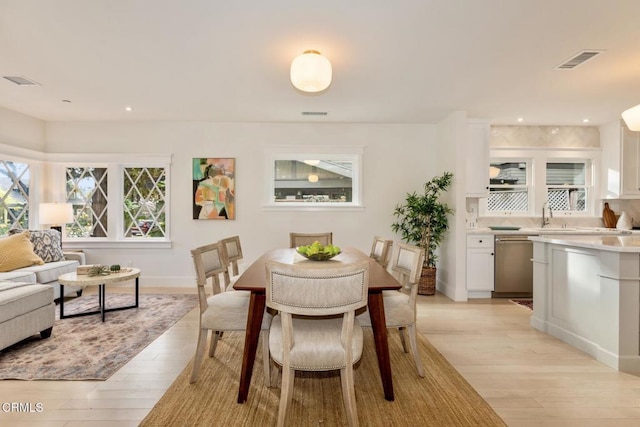 dining room featuring sink and light hardwood / wood-style floors