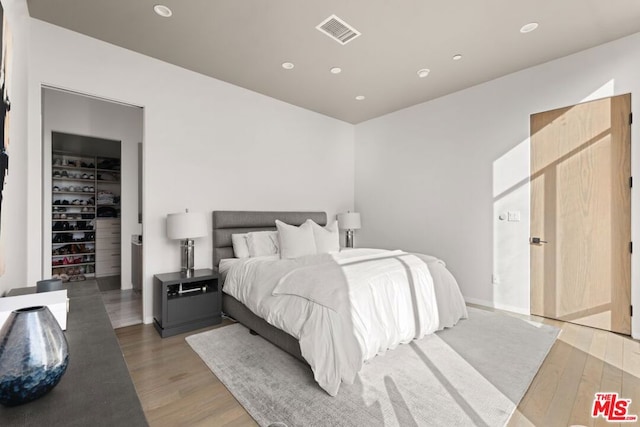 bedroom featuring a spacious closet, dark hardwood / wood-style floors, and a closet