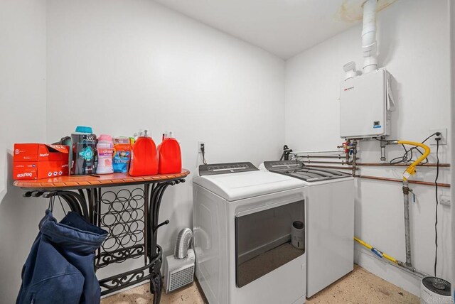 laundry room with washer and clothes dryer and water heater