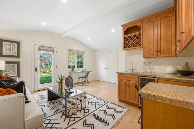 kitchen with lofted ceiling with beams, sink, beverage cooler, and light hardwood / wood-style flooring